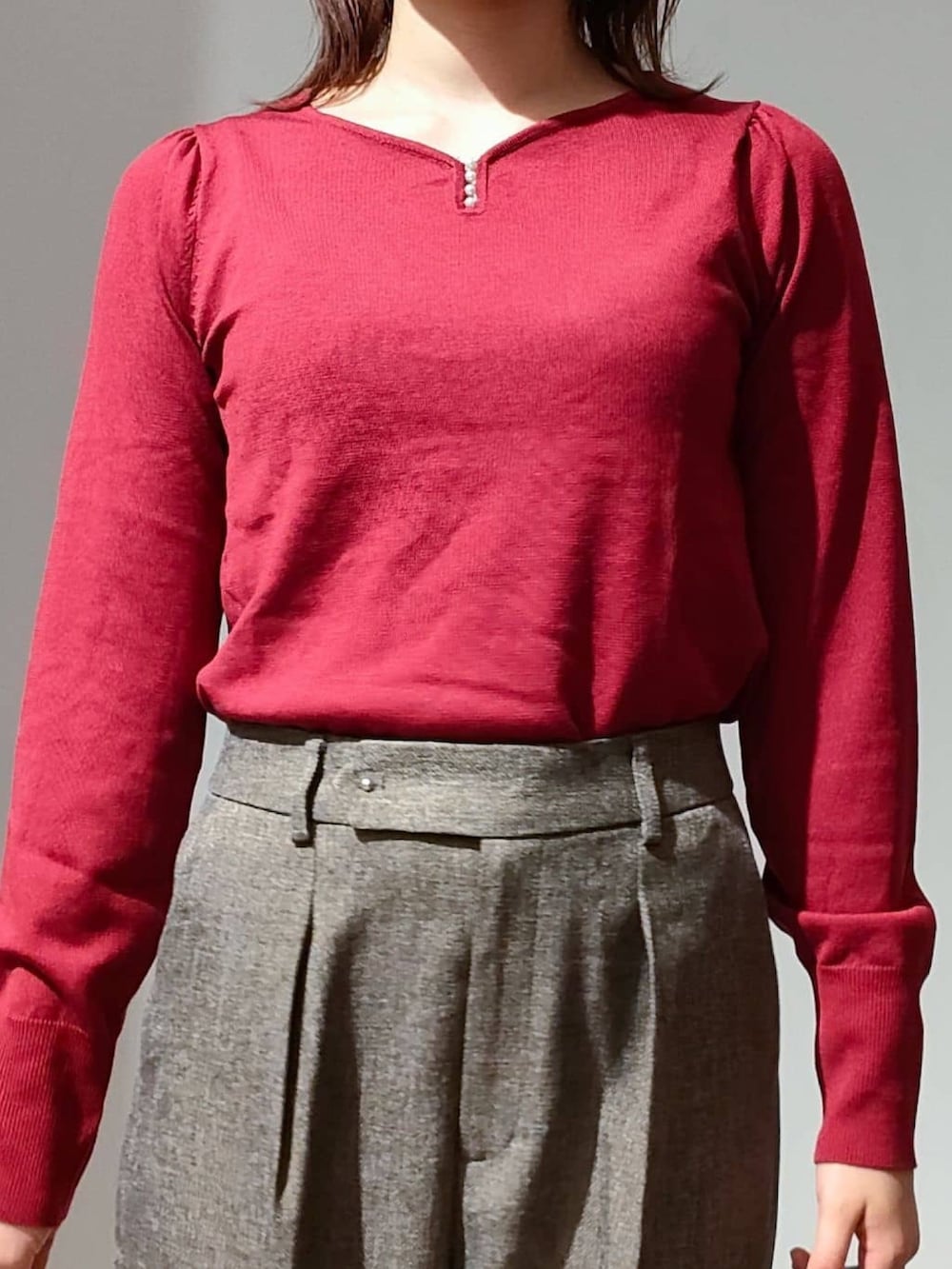 レッド系のニット/セーター、ブラウン系のその他パンツ、ブラック系のショルダーバッグを着用したレディースの秋コーディネートの2枚目の写真