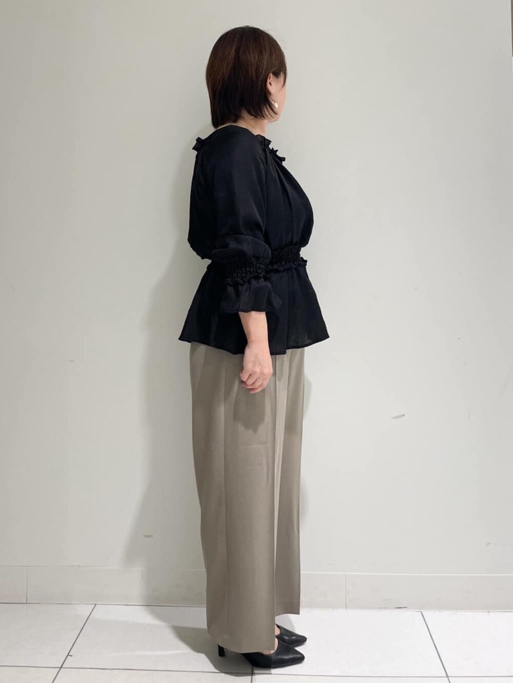ブラック系のシャツ/ブラウス、ベージュ系のその他パンツ、ブラック系のパンプスを着用したレディースの秋コーディネートの3枚目の写真