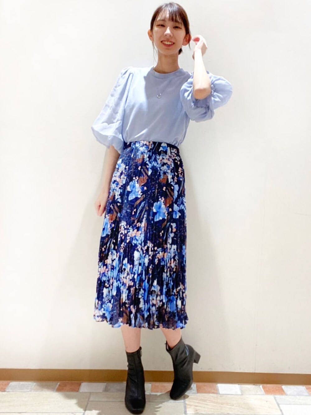 ブルー系のTシャツ/カットソー、ブルー系のスカート、ブラック系のブーツを着用したレディースの秋コーディネートの2枚目の写真