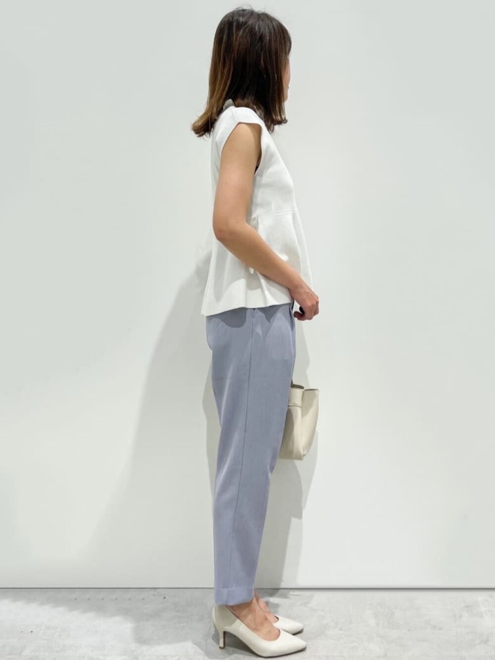 ブルー系のその他パンツ、ホワイト系のニット/セーター、ホワイト系のパンプスを着用したレディースの春コーディネートの2枚目の写真