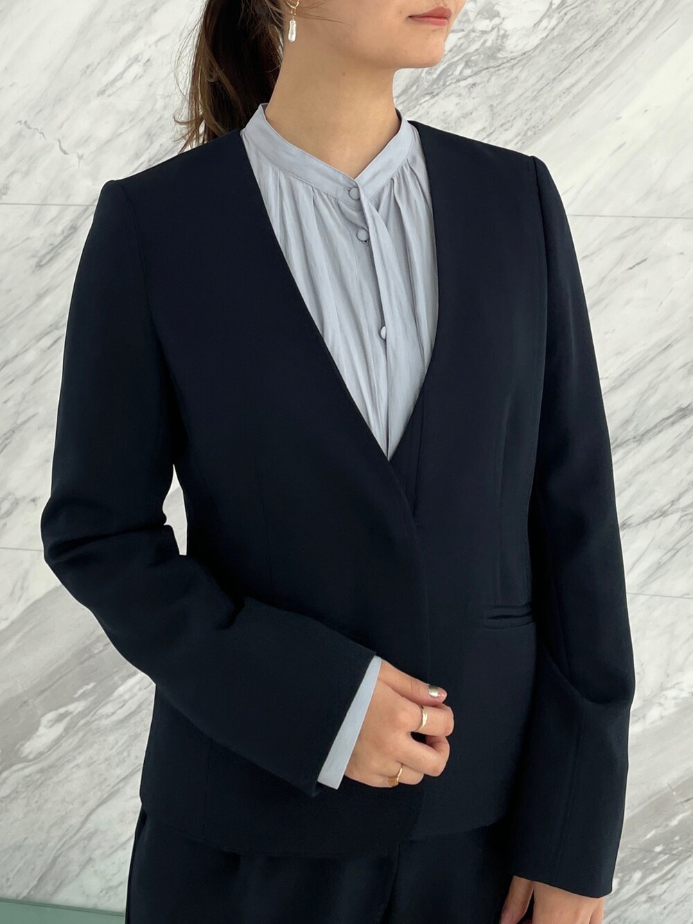 ブルー系のシャツ/ブラウス、ブルー系のスーツジャケット、ブルー系のスーツパンツを着用したレディースの冬コーディネートの2枚目の写真