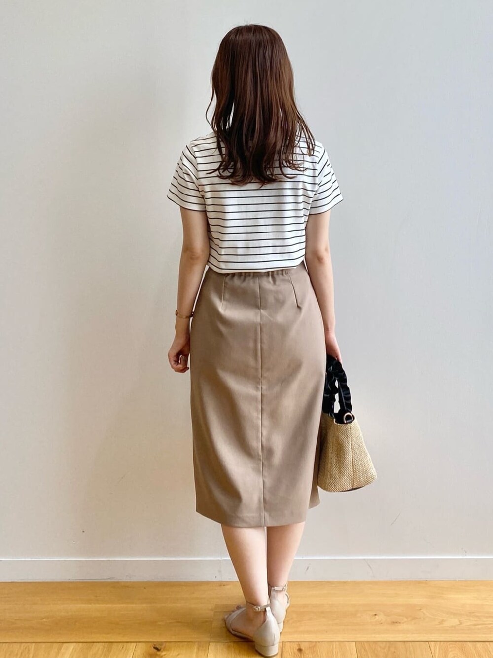 ホワイト系のTシャツ/カットソー、ブラウン系のスカート、ブラック系のトートバッグを着用したレディースの夏コーディネートの4枚目の写真
