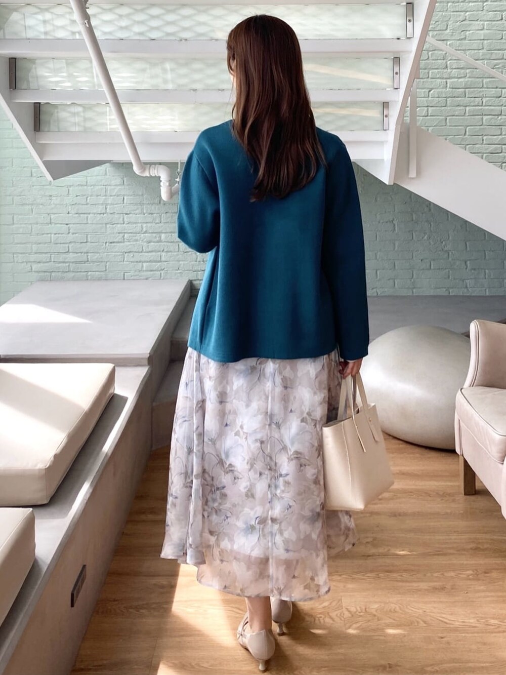 ブルー系のカーディガン/ボレロ、ベージュ系のシャツ/ブラウス、グレー系のスカートを着用したレディースの秋コーディネートの4枚目の写真