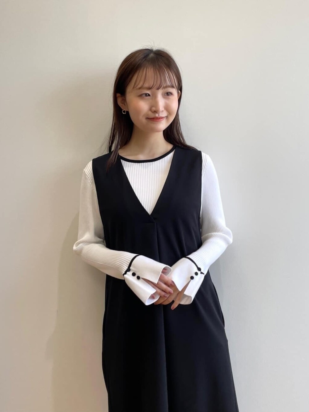 ホワイト系のニット/セーター、ブラック系のスカート、ブラック系のその他シューズを着用したレディースの春コーディネートの8枚目の写真