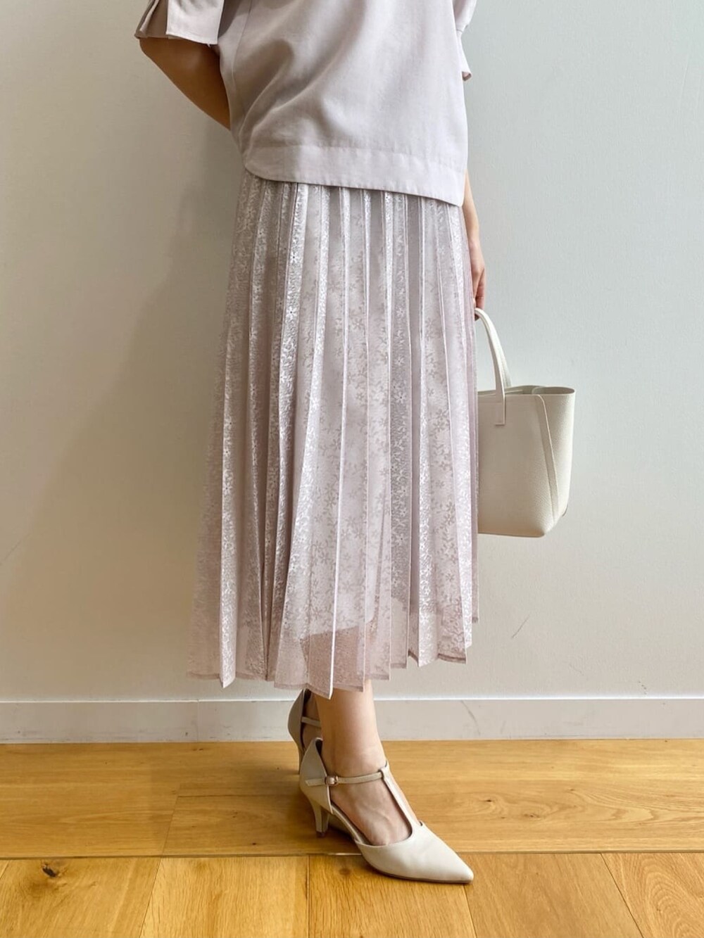 ベージュ系のシャツ/ブラウス、ベージュ系のスカート、ホワイト系のトートバッグを着用したレディースの夏コーディネートの9枚目の写真