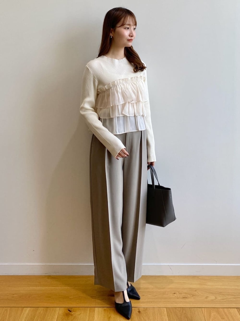 ホワイト系のニット/セーター、ベージュ系のその他パンツ、グレー系のトートバッグを着用したレディースの秋コーディネートの3枚目の写真