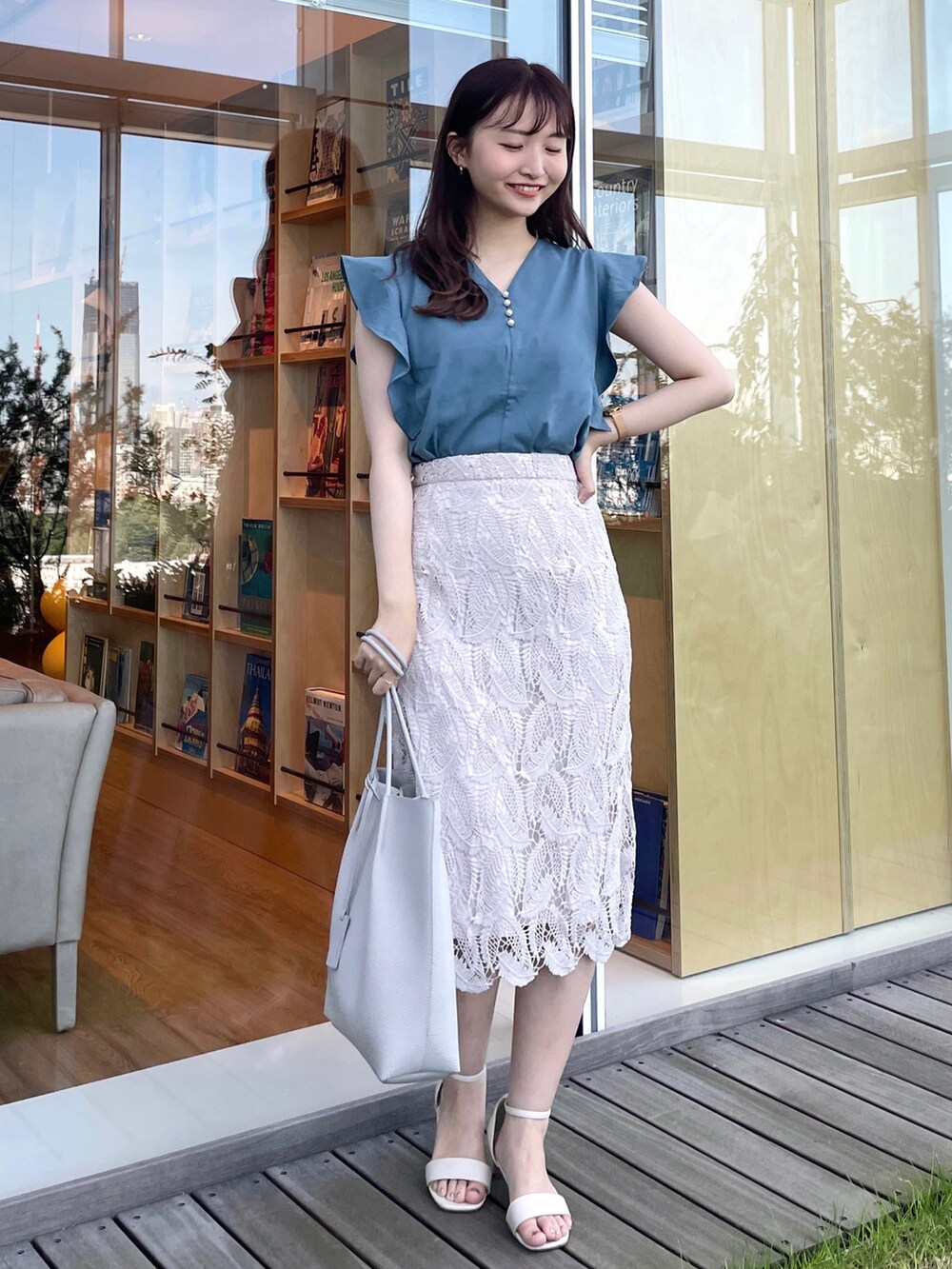 ブルー系のTシャツ/カットソー、グレー系のスカート、グレー系のトートバッグを着用したレディースの夏コーディネートの2枚目の写真