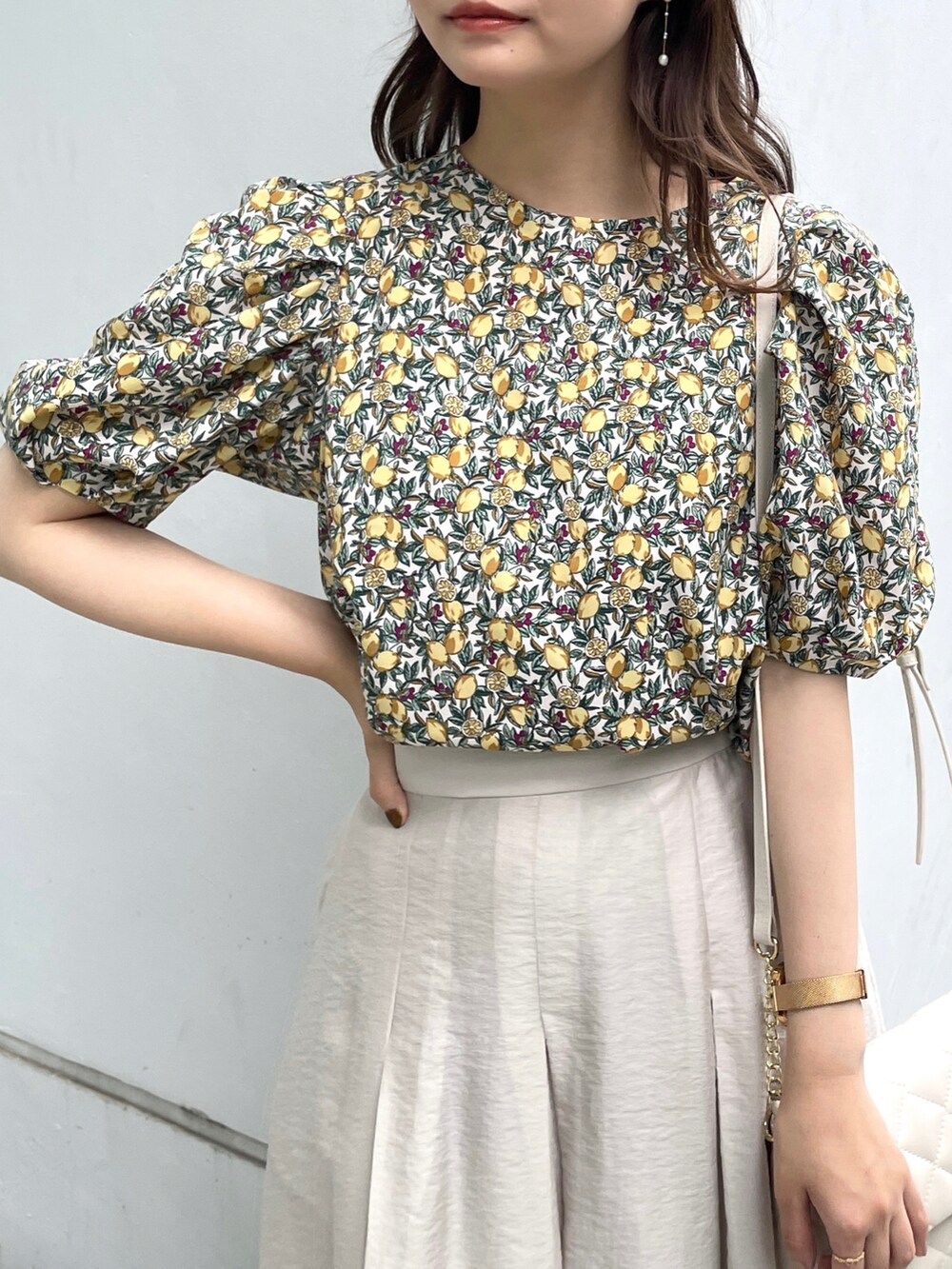 グレー系のスカート、ホワイト系のサンダル、ホワイト系のショルダーバッグを着用したレディースの夏コーディネートの5枚目の写真