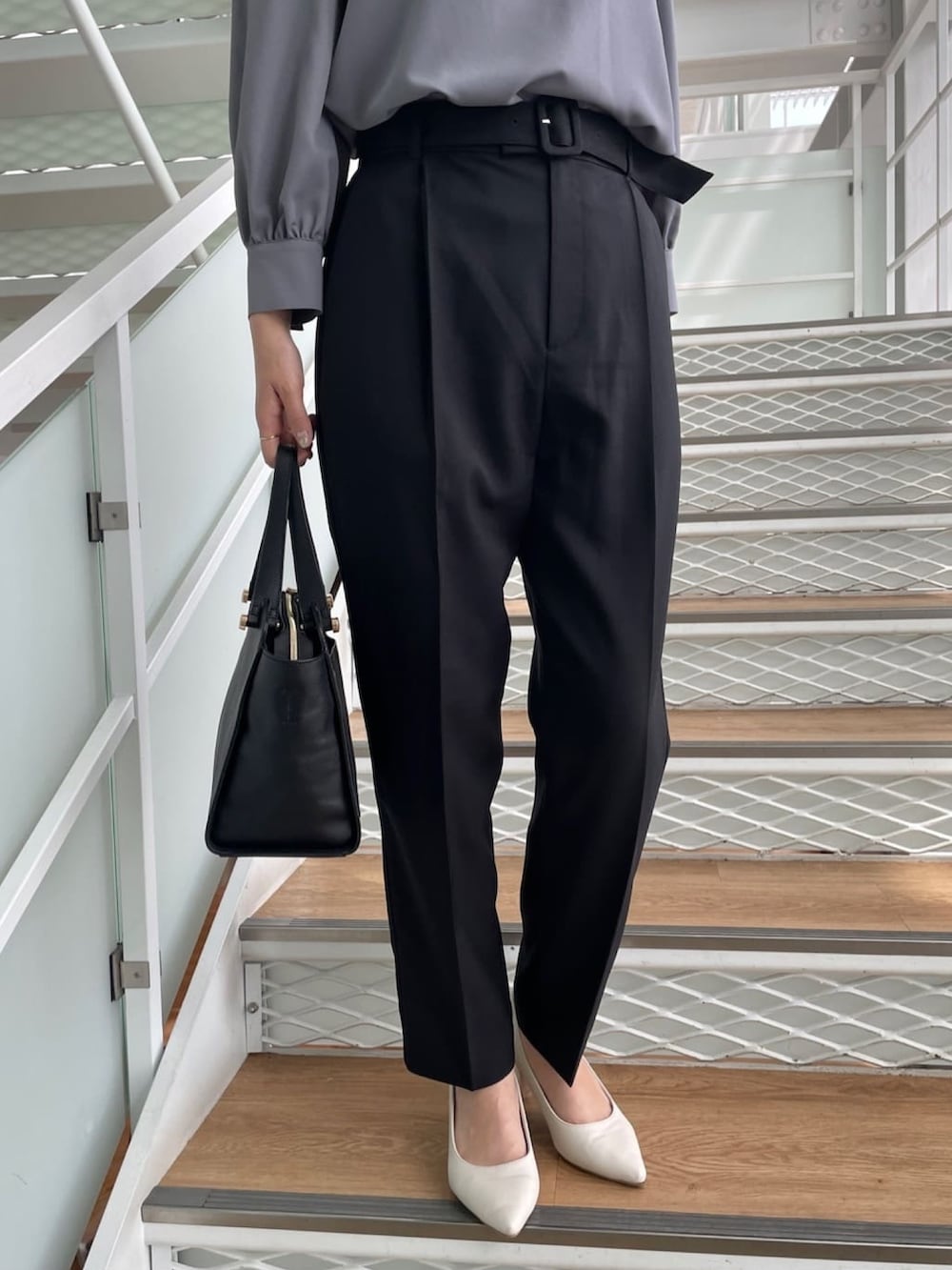 グレー系のシャツ/ブラウス、ブラック系のその他パンツ、ホワイト系のパンプスを着用したレディースの春コーディネートの5枚目の写真