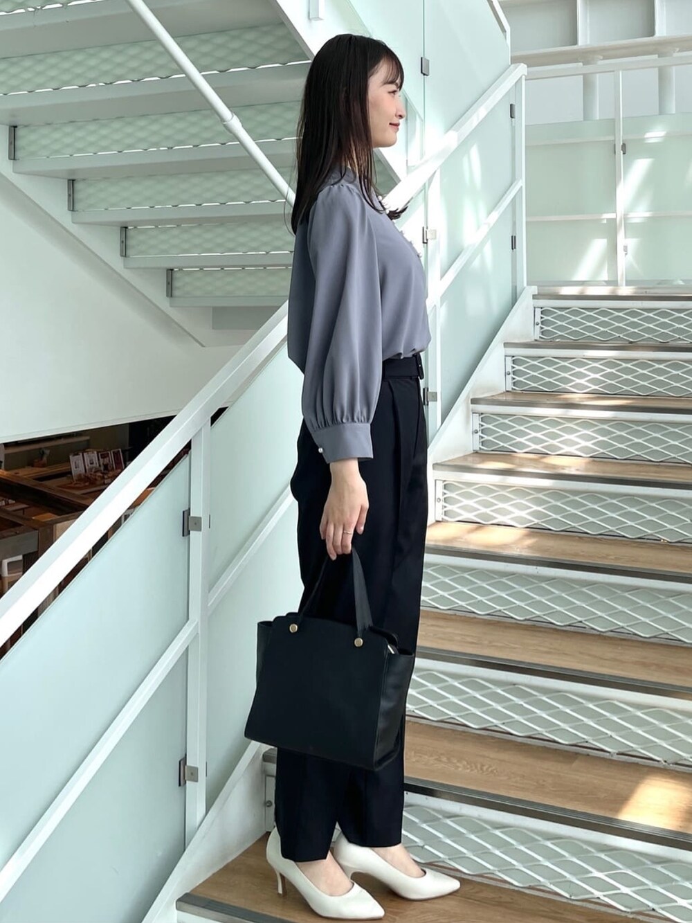 グレー系のシャツ/ブラウス、ブラック系のその他パンツ、ホワイト系のパンプスを着用したレディースの春コーディネートの2枚目の写真