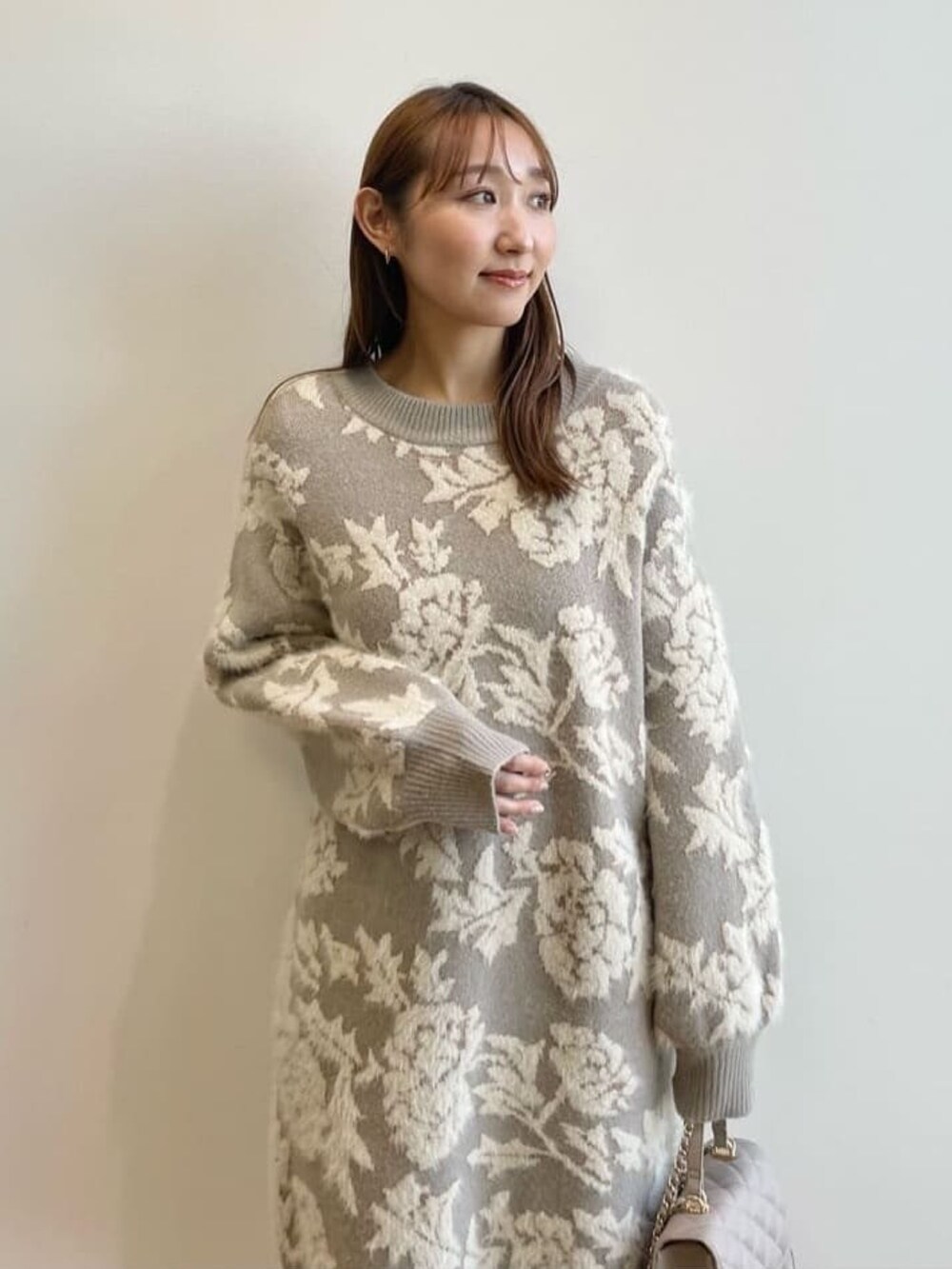 グレー系のワンピース、ベージュ系のショルダーバッグ、ベージュ系のブーツを着用したレディースの冬コーディネートの4枚目の写真