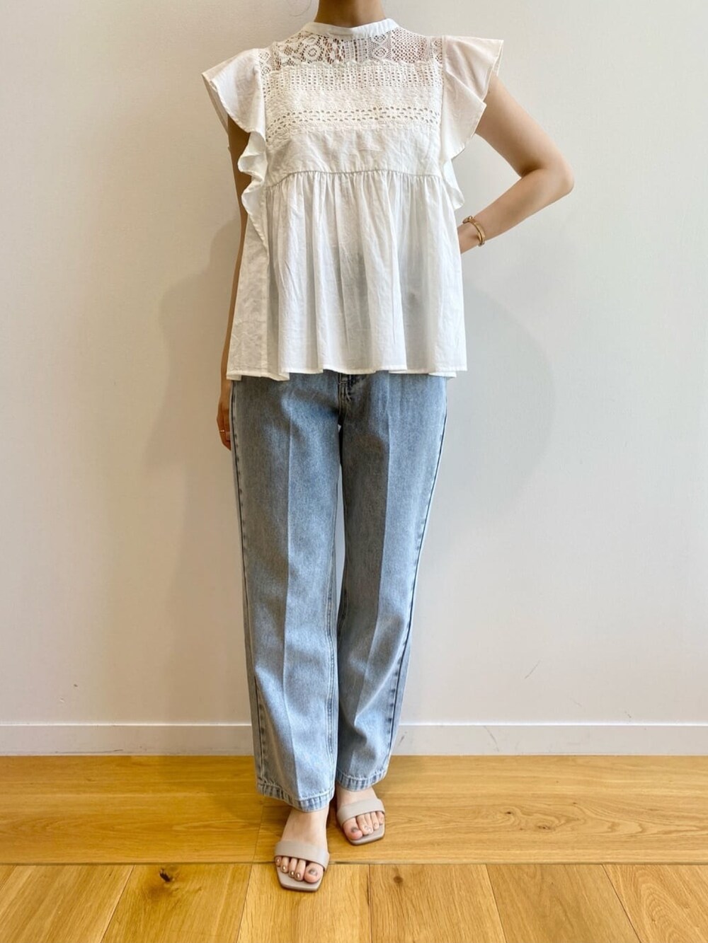 ブルー系のデニムパンツ、ベージュ系のサンダル、ホワイト系のシャツ/ブラウスを着用したレディースの夏コーディネートの10枚目の写真