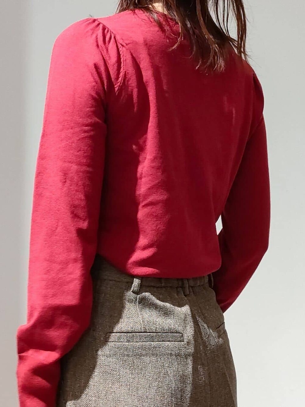 レッド系のニット/セーター、ブラウン系のその他パンツ、ブラック系のショルダーバッグを着用したレディースの秋コーディネートの8枚目の写真