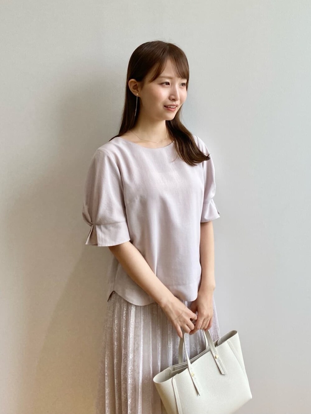 ベージュ系のシャツ/ブラウス、ベージュ系のスカート、ホワイト系のトートバッグを着用したレディースの夏コーディネートの6枚目の写真