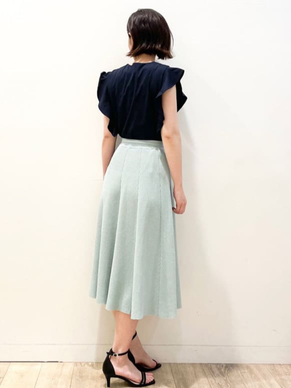 ブルー系のTシャツ/カットソー、グリーン系のスカート、ブラック系のサンダルを着用したレディースの夏コーディネートの3枚目の写真