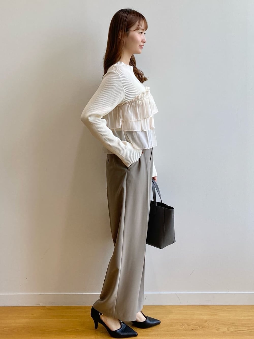 ホワイト系のニット/セーター、ベージュ系のその他パンツ、グレー系のトートバッグを着用したレディースの秋コーディネートの4枚目の写真