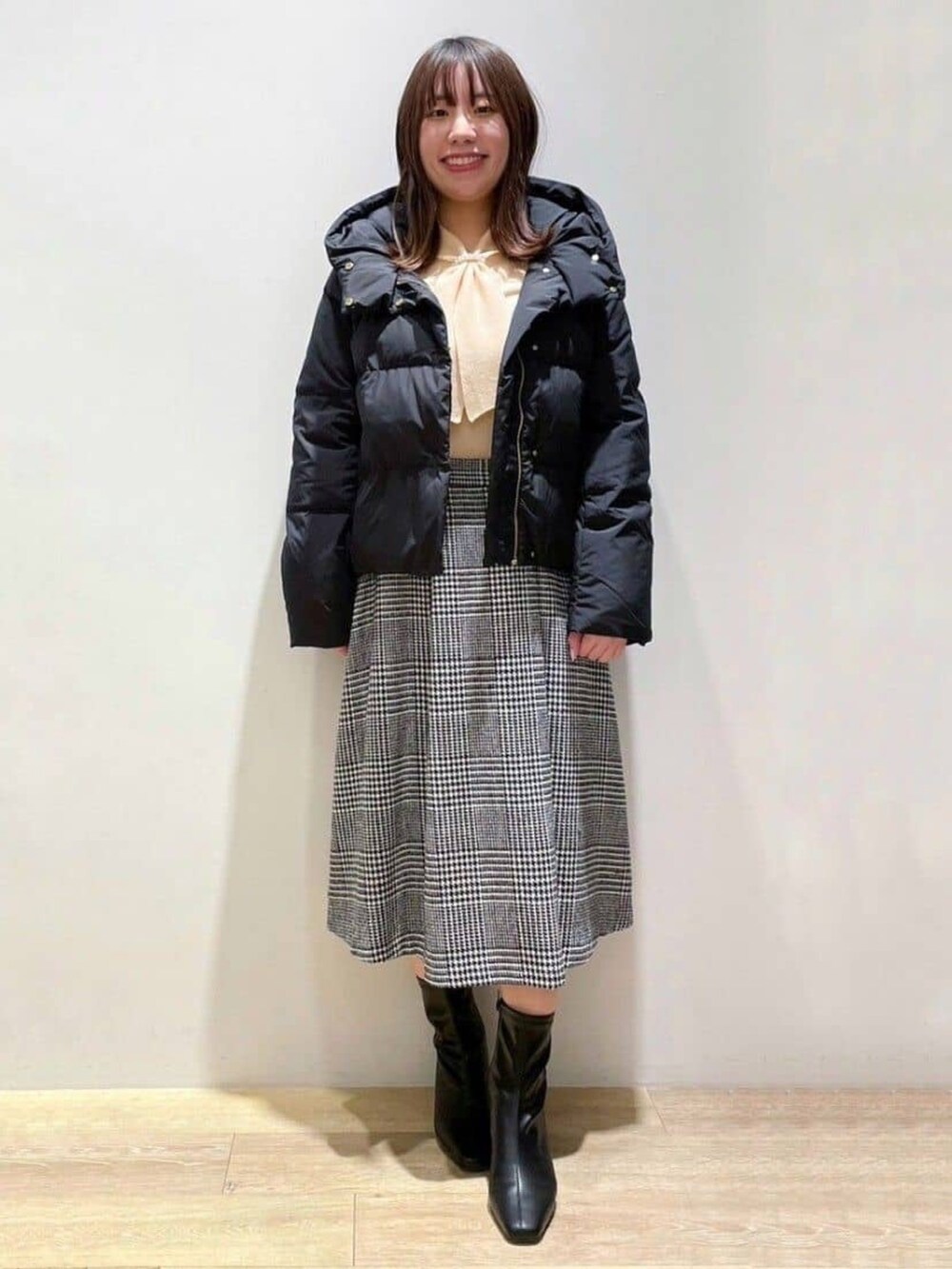 ブラック系のスカート、オレンジ系のニット/セーター、ブラック系のトートバッグを着用したレディースの冬コーディネートの4枚目の写真