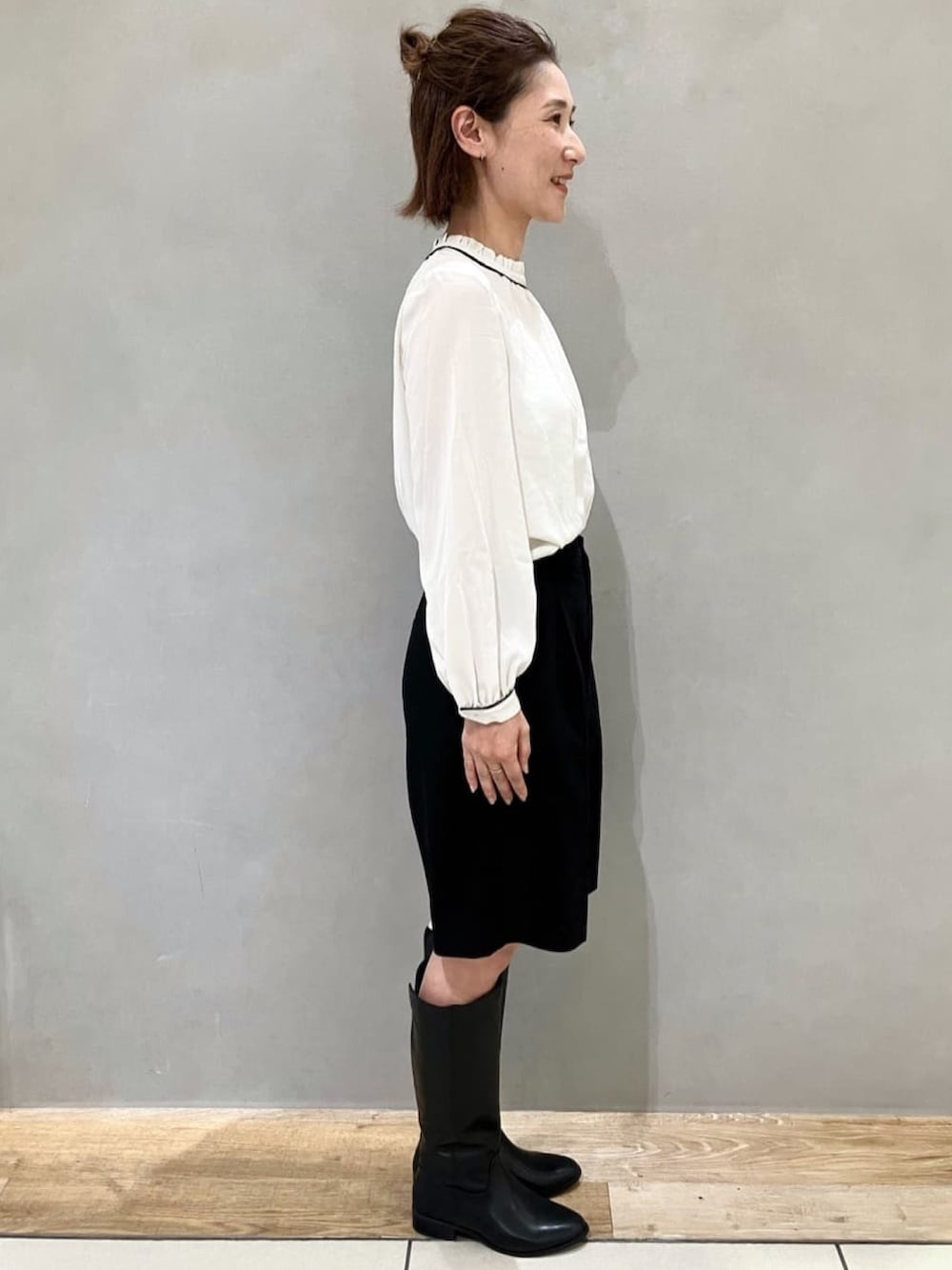 ホワイト系のシャツ/ブラウス、ブラック系のその他パンツ、ブラック系のブーツを着用したレディースの秋コーディネートの2枚目の写真