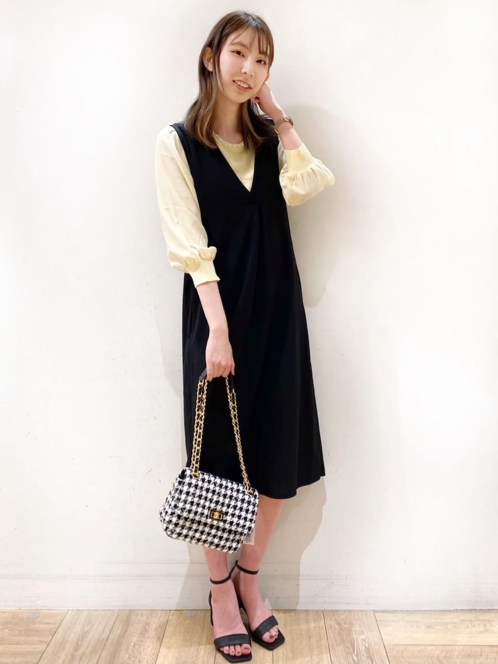 イエロー系のニット/セーター、ブラック系のサンダル、ブラック系のスカートを着用したレディースの春コーディネートの3枚目の写真