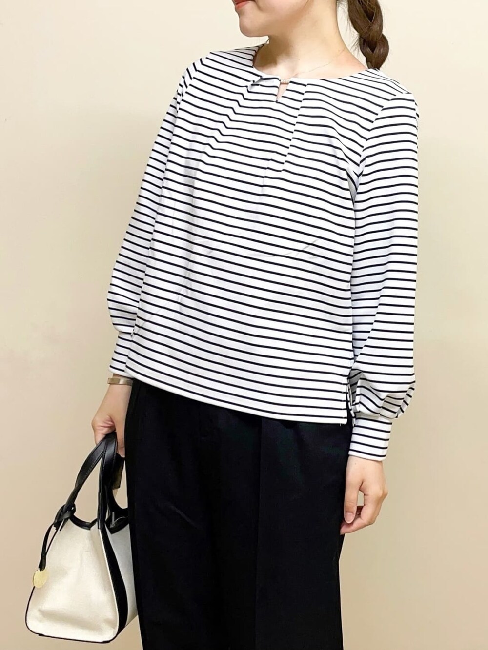 ホワイト系のTシャツ/カットソー、ベージュ系のパンプス、ブラック系のその他パンツを着用したレディースの春コーディネートの2枚目の写真