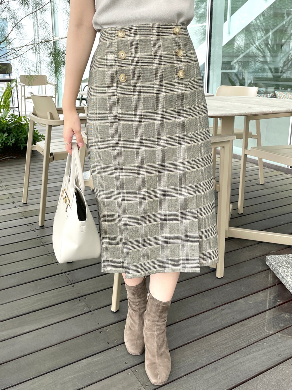 ベージュ系のスカート、ベージュ系のニット/セーター、ベージュ系のトートバッグを着用したレディースの夏コーディネートの5枚目の写真