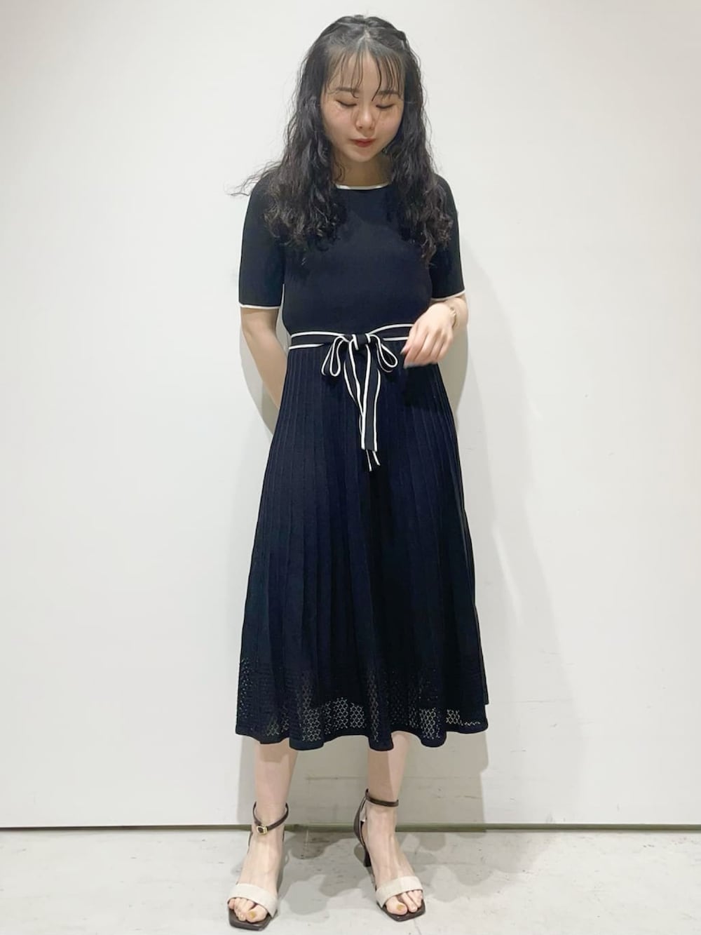 ブラック系のワンピース、グレー系のカーディガン/ボレロ、ベージュ系のサンダルを着用したレディースの春コーディネートの3枚目の写真