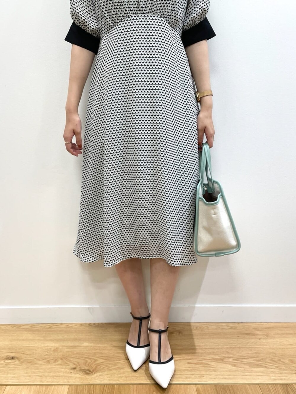 ベージュ系のワンピース、グリーン系のトートバッグ、その他のパンプスを着用したレディースの夏コーディネートの4枚目の写真