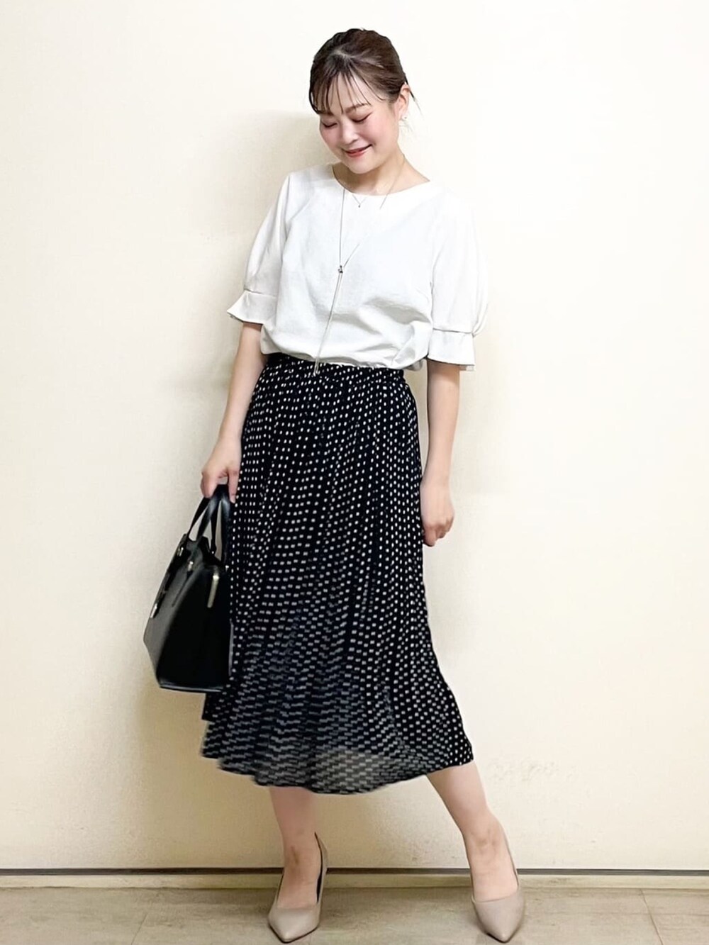 ホワイト系のシャツ/ブラウス、ブラック系のスカート、ブラック系のトートバッグを着用したレディースの春コーディネートの2枚目の写真