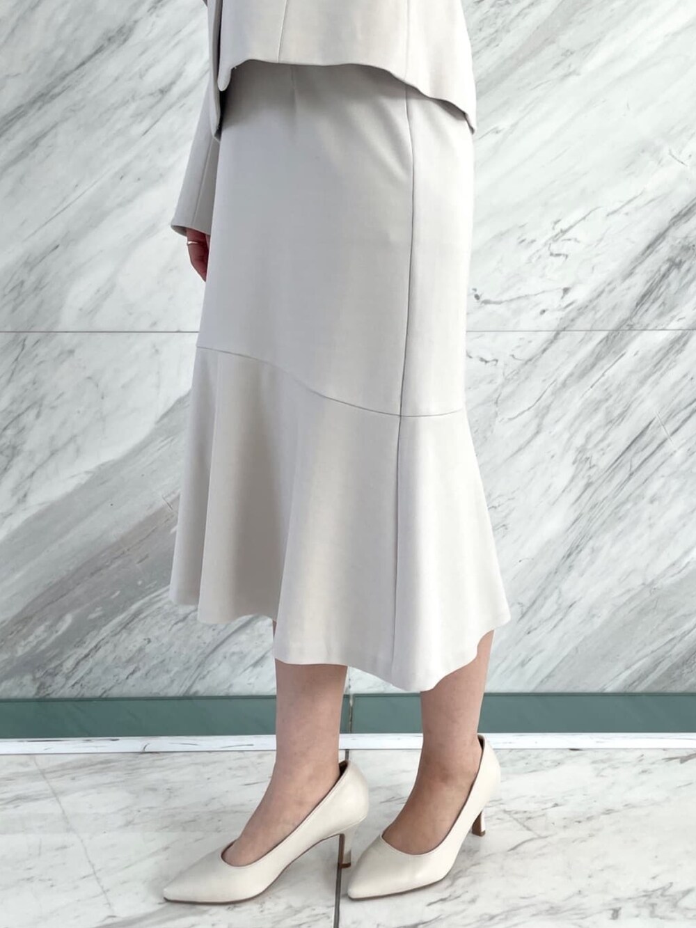 グレー系のスカート、ベージュ系のトートバッグ、ホワイト系のシャツ/ブラウスを着用したレディースの冬コーディネートの6枚目の写真