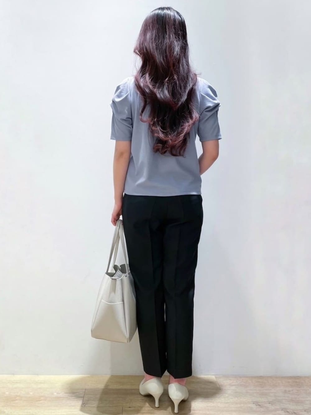 ブルー系のTシャツ/カットソー、ブラック系のその他パンツ、ホワイト系のパンプスを着用したレディースの春コーディネートの3枚目の写真