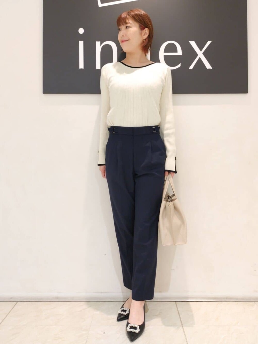 ベージュ系のニット/セーター、グレー系のカーディガン/ボレロ、ブラック系のトートバッグを着用したレディースの秋コーディネートの4枚目の写真