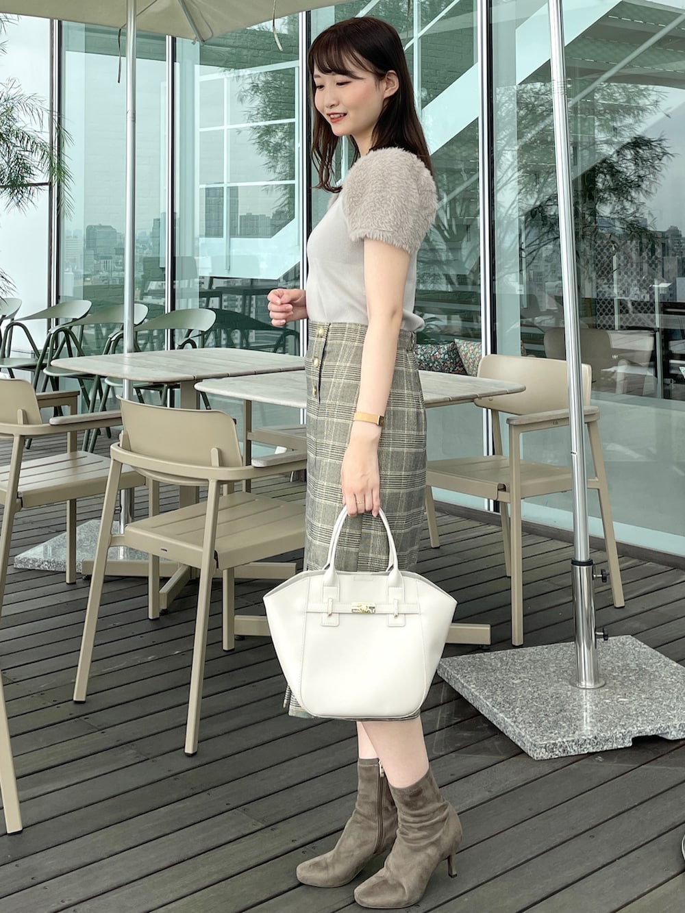 ベージュ系のスカート、ベージュ系のニット/セーター、ベージュ系のトートバッグを着用したレディースの夏コーディネートの2枚目の写真