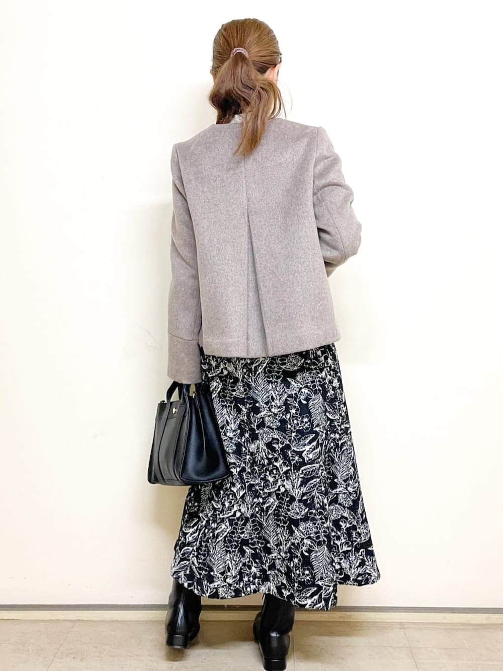 ベージュ系のニット/セーター、ブラック系のスカート、ブラック系のトートバッグを着用したレディースの冬コーディネートの4枚目の写真