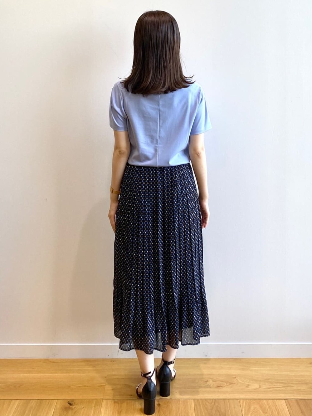 ブラック系のスカート、ブルー系のTシャツ/カットソー、ブラック系のサンダルを着用したレディースの夏コーディネートの3枚目の写真