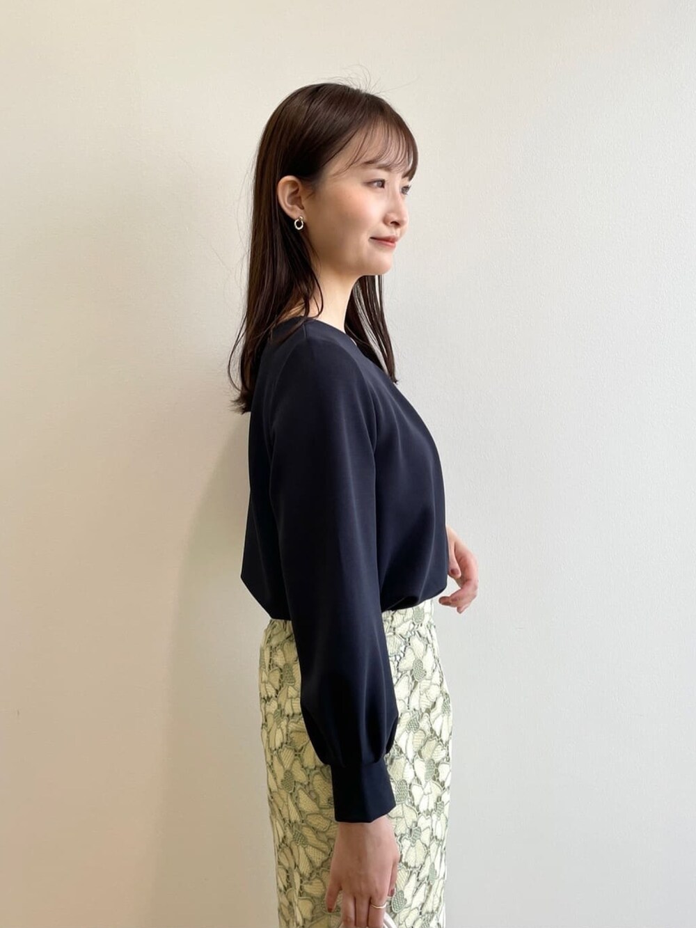 ブルー系のTシャツ/カットソー、イエロー系のスカート、グリーン系のパンプスを着用したレディースの春コーディネートの5枚目の写真