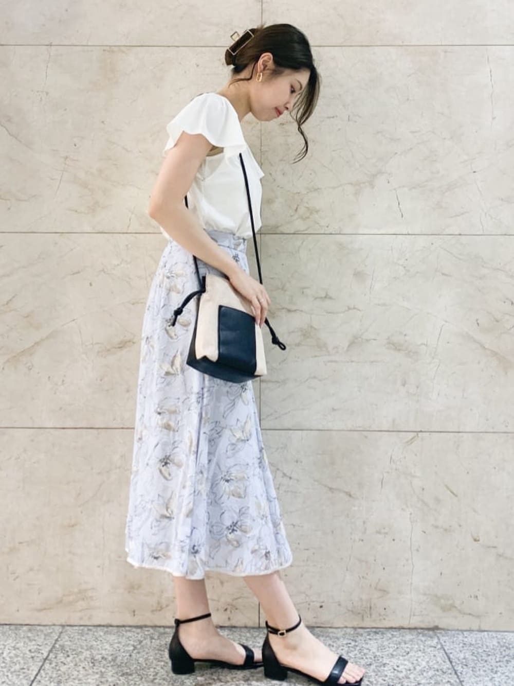 ホワイト系のTシャツ/カットソー、ブルー系のスカート、ベージュ系のショルダーバッグを着用したレディースの夏コーディネートの2枚目の写真