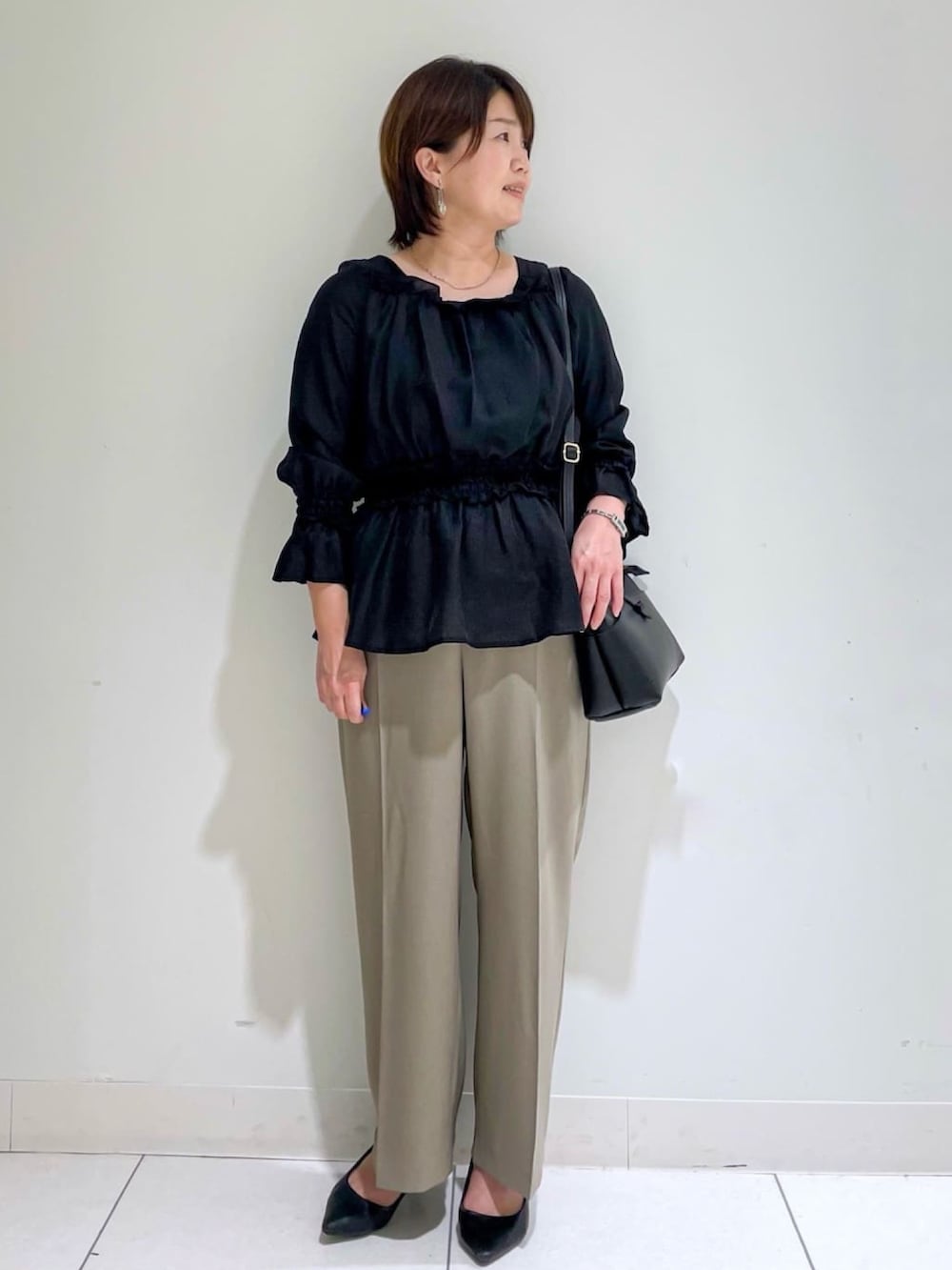 ブラック系のシャツ/ブラウス、ベージュ系のその他パンツ、ブラック系のパンプスを着用したレディースの秋コーディネートの2枚目の写真
