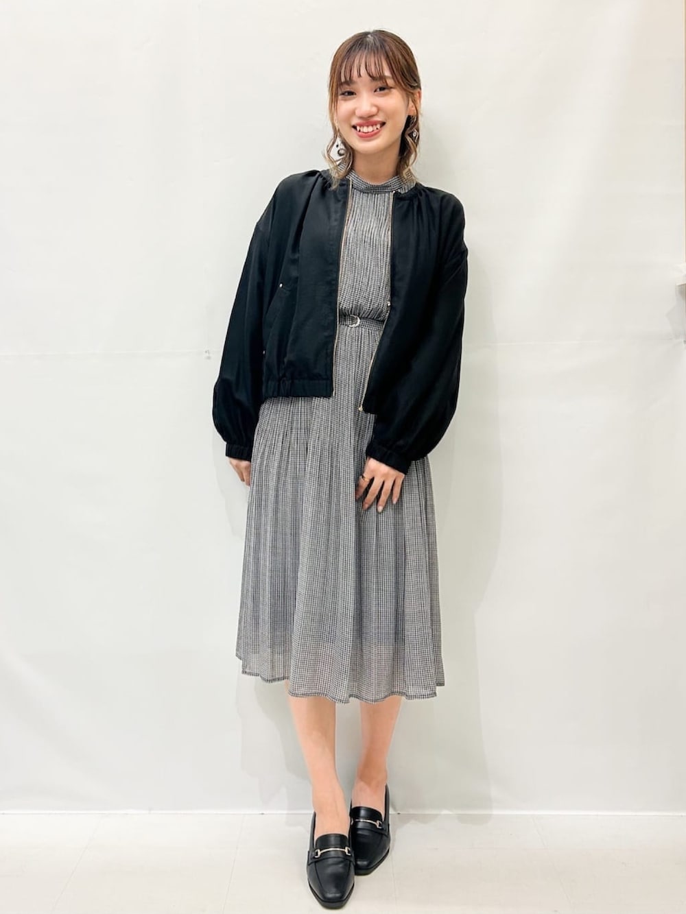 ブラック系のブルゾン、ブラック系のワンピース、ブラック系のパンプスを着用したレディースの秋コーディネートの2枚目の写真