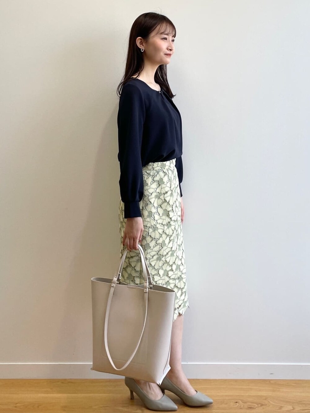 ブルー系のTシャツ/カットソー、イエロー系のスカート、グリーン系のパンプスを着用したレディースの春コーディネートの2枚目の写真