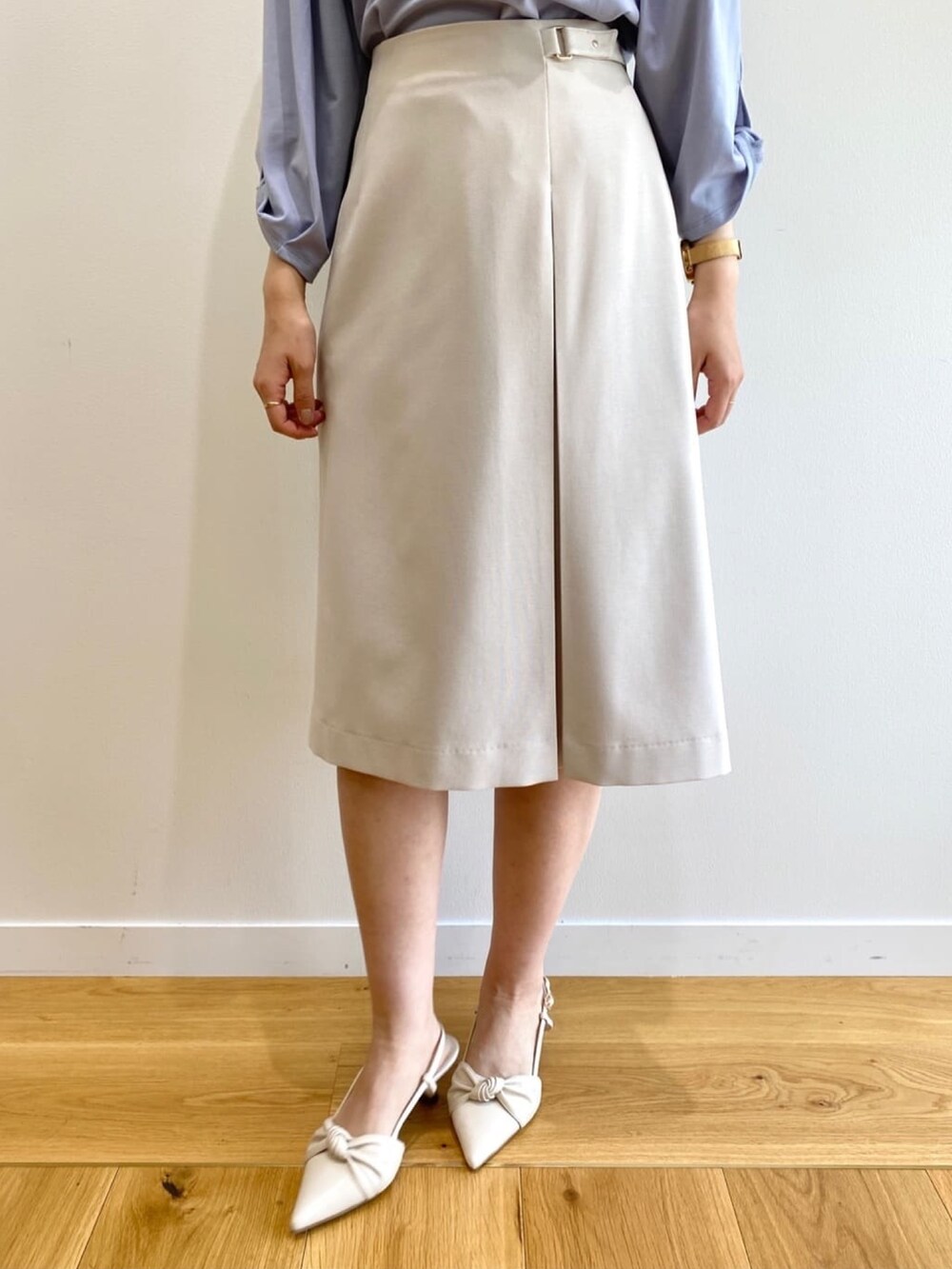 グレー系のスカート、ブルー系のTシャツ/カットソー、ホワイト系のパンプスを着用したレディースの春コーディネートの8枚目の写真