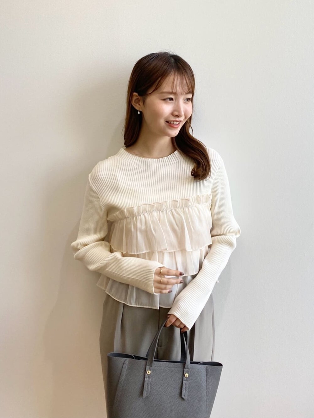 ホワイト系のニット/セーター、ベージュ系のその他パンツ、グレー系のトートバッグを着用したレディースの秋コーディネートの8枚目の写真