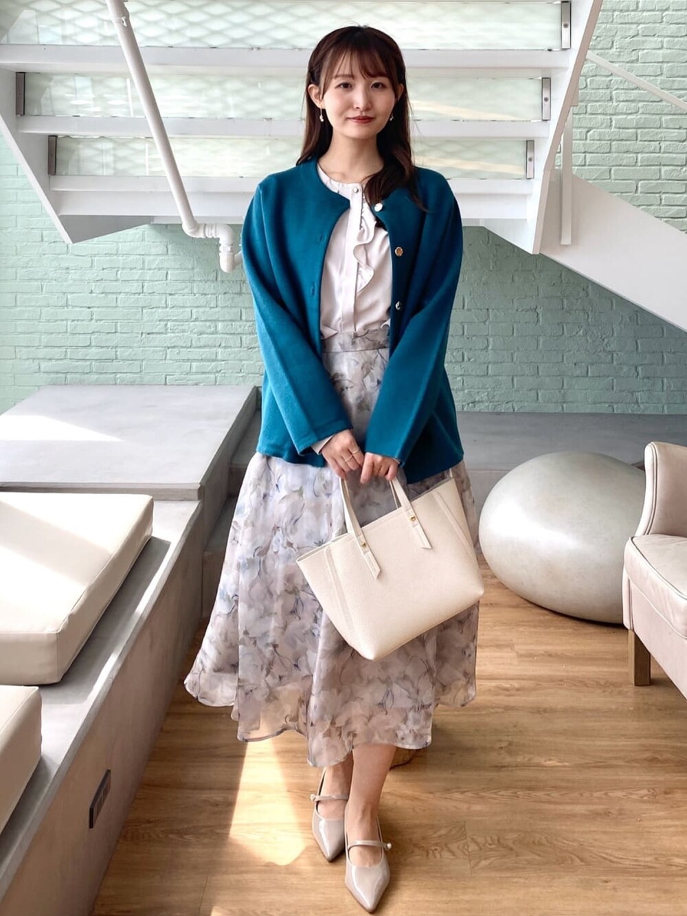 ブルー系のカーディガン/ボレロ、ベージュ系のシャツ/ブラウス、グレー系のスカートを着用したレディースの秋コーディネートの2枚目の写真