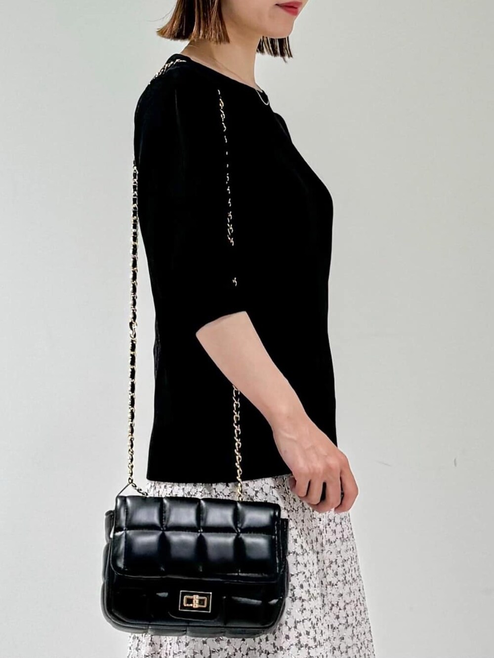 ブラック系のニット/セーター、ベージュ系のサンダル、ベージュ系のスカートを着用したレディースの夏コーディネートの5枚目の写真