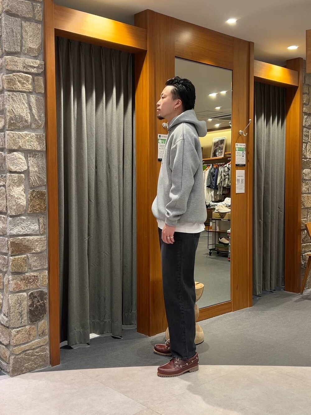 グレー系のパーカー、ブラック系のデニムパンツを着用したメンズの秋コーディネートの2枚目の写真