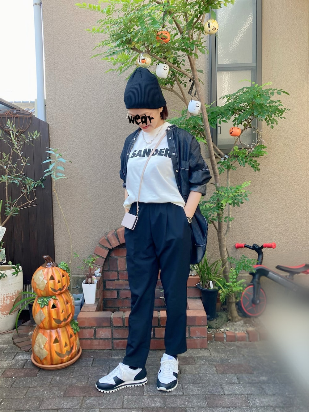 ホワイト系のTシャツ/カットソー、ホワイト系のスニーカー、ブラック系のスラックスを着用したレディースの秋コーディネートの2枚目の写真