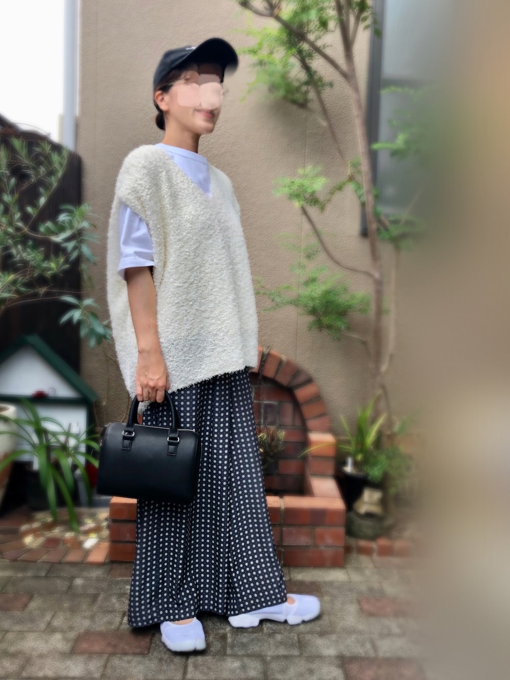 ブラック系のボストンバッグ、ブルー系のその他パンツ、ホワイト系のスニーカーを着用したレディースの秋コーディネートの2枚目の写真