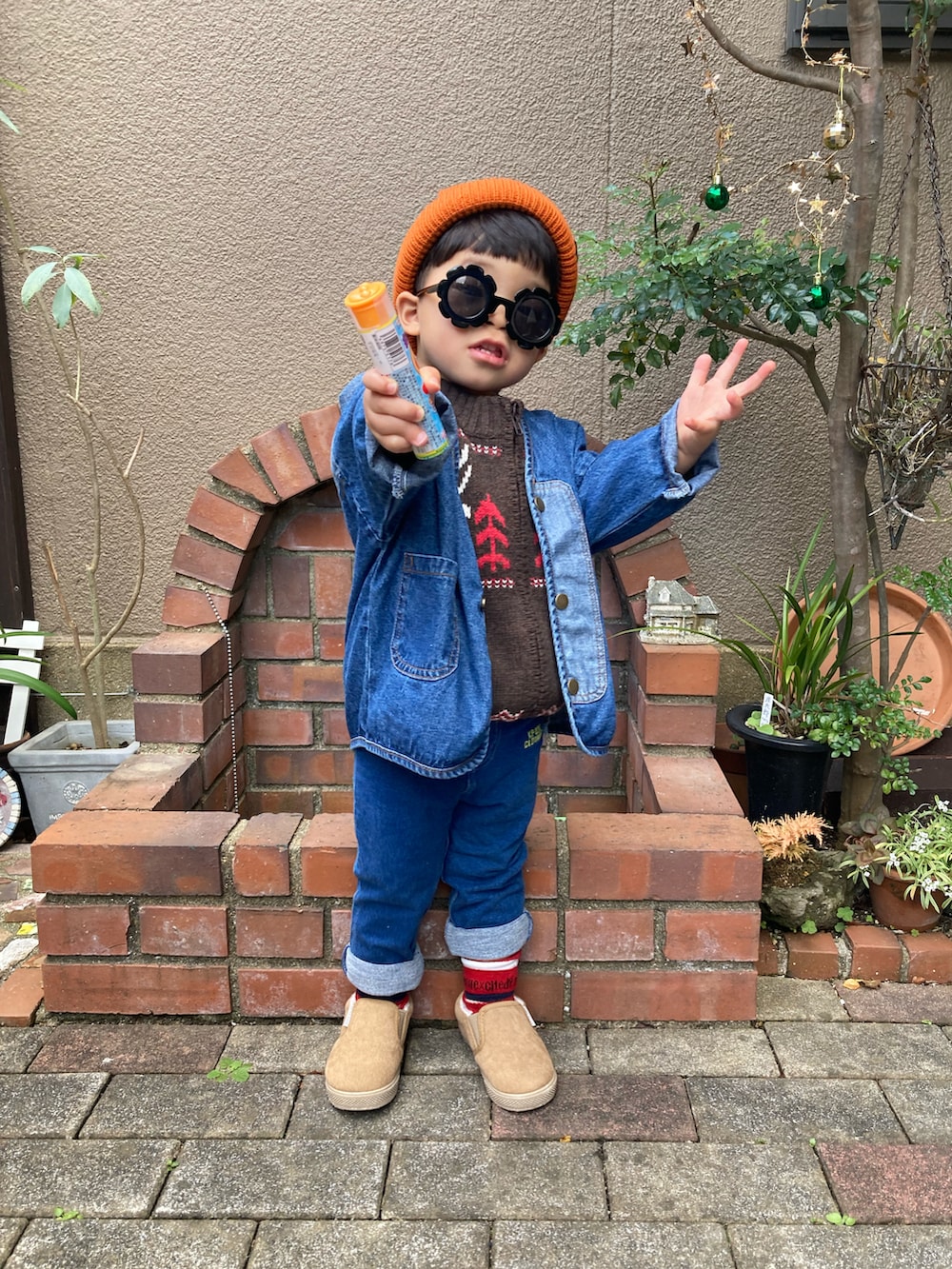 ブラウン系のニット/セーター、ブルー系のノーカラージャケット、ベージュ系のスリッポンを着用したキッズの冬コーディネートの2枚目の写真