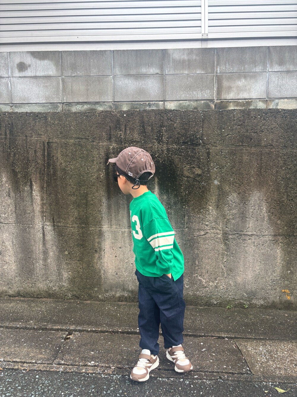 ブラウン系のスニーカー、グリーン系のTシャツ/カットソー、ブルー系のデニムパンツを着用したキッズの秋コーディネートの3枚目の写真