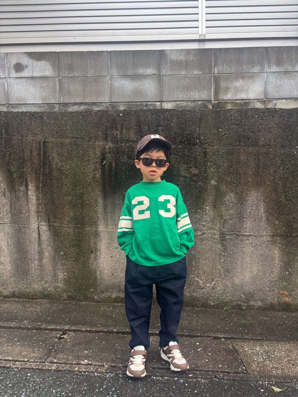 ブラウン系のスニーカー、グリーン系のTシャツ/カットソー、ブルー系のデニムパンツを着用したキッズの秋コーディネートの2枚目の写真