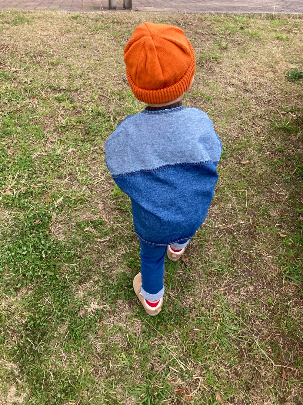 ブラウン系のニット/セーター、ブルー系のノーカラージャケット、ベージュ系のスリッポンを着用したキッズの冬コーディネートの3枚目の写真